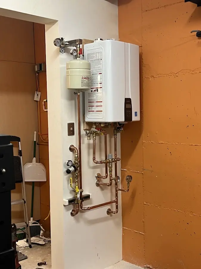 Plumbing technician inspecting water heater connections in Stanton